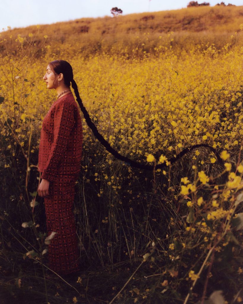 Aditi Mayer standing in a yellow flower field