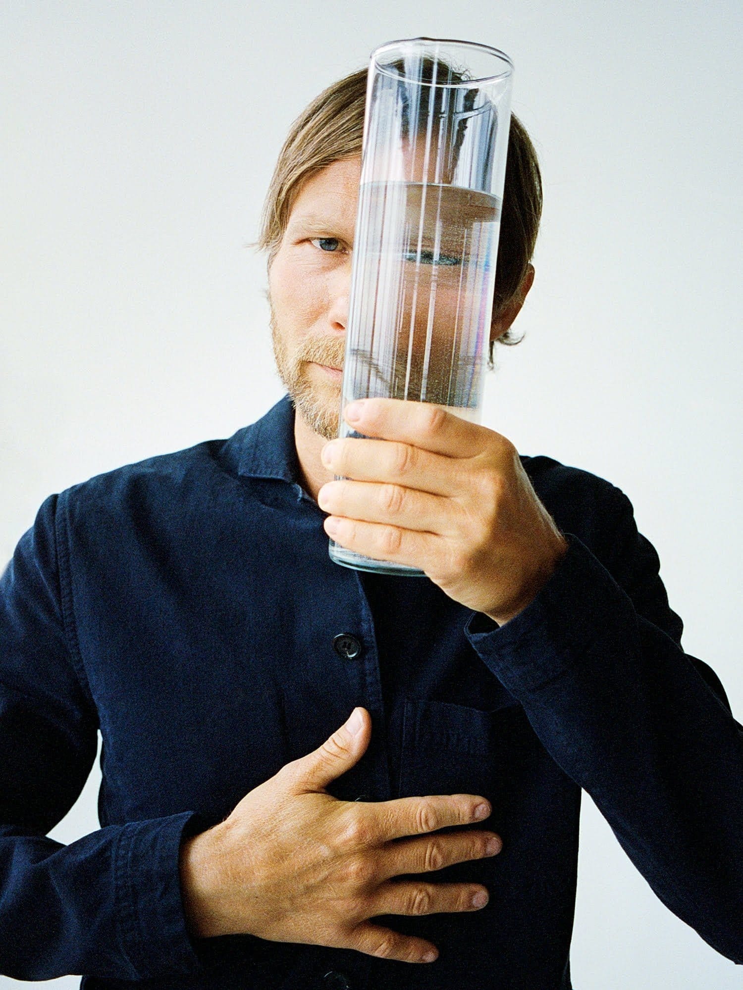 Chef and part-owner of restaurant Geranium in Copenhagen, Rasmus Kofoed, looking through a glass of water.