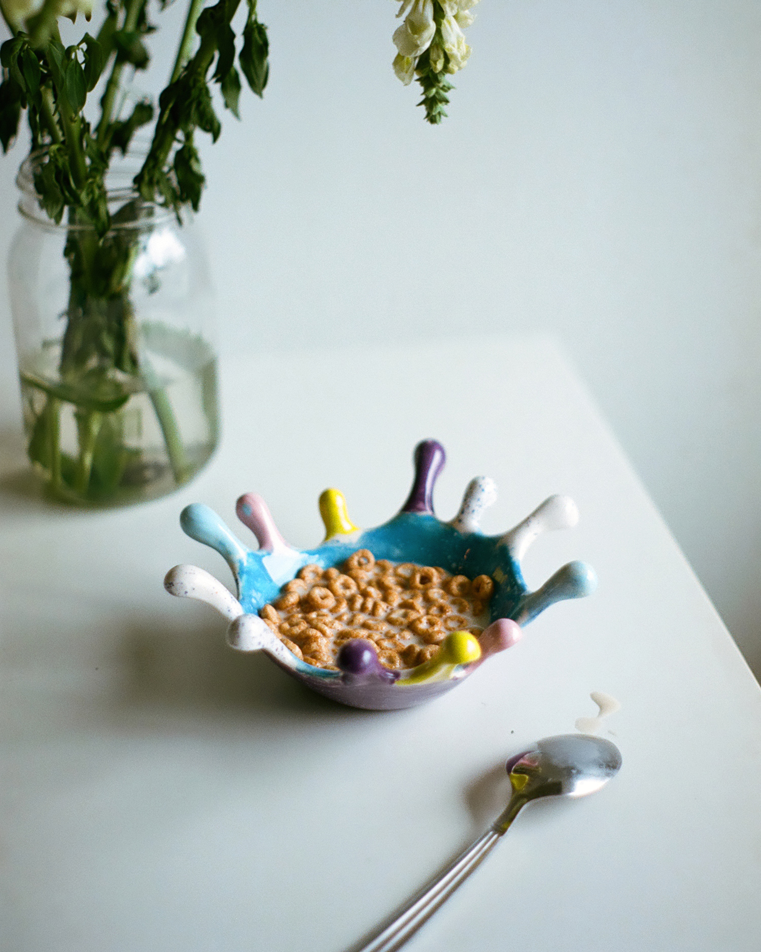 A bowl of breakfast cereal on a table served with plant-based milk.