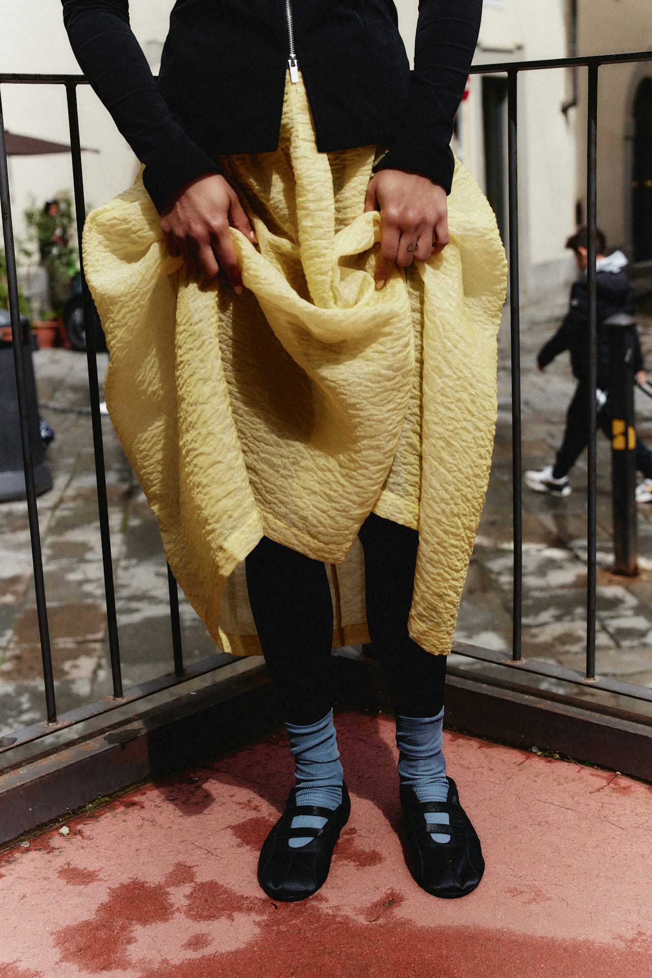 woman wearing various examples of slow fashion items. Pointe shoes combines with blue wool socks and a high-end dress